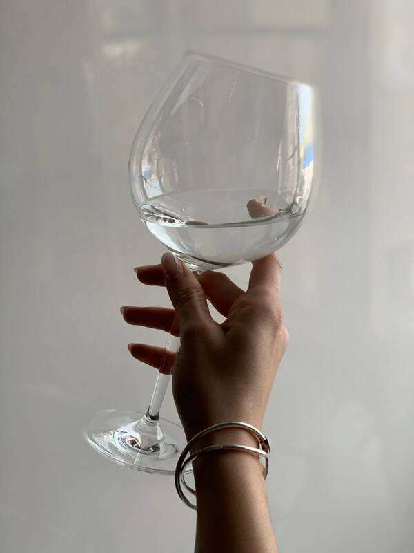 Glāze ar ūdeni uz galda pie dabiskas gaismas